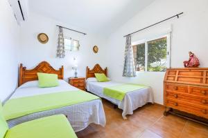 a bedroom with two beds and a window at YupiHome Finca Can Calistro in Inca
