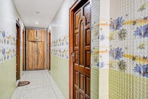 a hallway with a door and a tile wall at OYO Flagship The Rest in Gauripur
