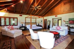 uma sala de estar com mobiliário branco e uma ventoinha de tecto em Sunny Vacation Villa No 43 em San Rafael del Yuma