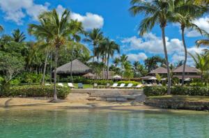 um resort com palmeiras e cadeiras na praia em Sunny Vacation Villa No 43 em San Rafael del Yuma