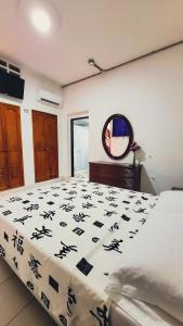 a bedroom with a bed with a black and white comforter at Hotel Beijing Cartagena in Cartagena de Indias