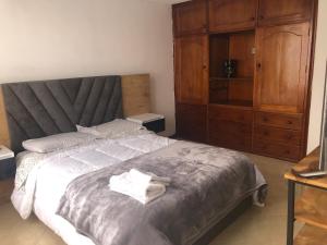 a bedroom with a large bed and a wooden cabinet at ERY total confort Pasto in Pasto