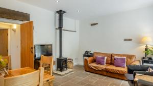 a living room with a couch and a wood stove at Kestrel Cottage in Chinley