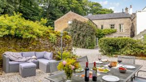 a patio with a table and chairs and a couch at Kestrel Cottage in Chinley