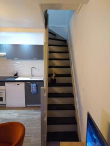 a stairway leading up to a kitchen with a stair case at Le triplex Côté plage plein Sud in Courseulles-sur-Mer
