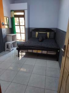 um quarto com uma cama num quarto em Budhis Home em Bromo