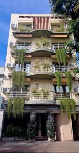 a building with plants on the balconies of it at Apart Hotel Rio Grande in Rosario