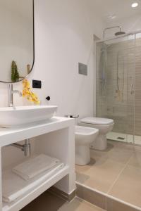 a white bathroom with a sink and a toilet at Tusa Bay in Castel di Tusa