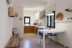 a kitchen with a white table and blue chairs at Tusa Bay in Castel di Tusa