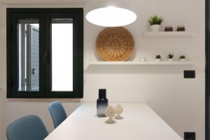 a dining room with a white table and blue chairs at Tusa Bay in Castel di Tusa