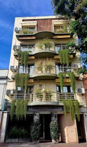 Apart Hotel Rio Grande في روزاريو: مبنى عليه نباتات على شرفات