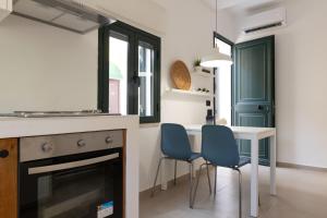 a kitchen with a table and two blue chairs at Tusa Bay in Castel di Tusa