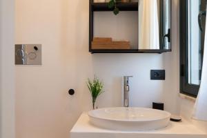 a bathroom with a white sink and a mirror at Tusa Bay in Castel di Tusa