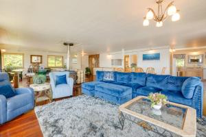 a living room with a blue couch and chairs at Waterfront Coos Bay Retreat with Kayaks! in Coos Bay