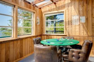 a dining room with a green table and chairs at Waterfront Coos Bay Retreat with Kayaks! in Coos Bay