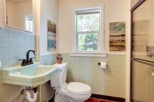 a bathroom with a toilet and a sink and a window at Waterfront Coos Bay Retreat with Kayaks! in Coos Bay +23 photos