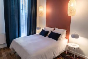 a bedroom with a white bed and a window at Coco: hypercentre-2chambres-parking-zen... in Saint-Étienne