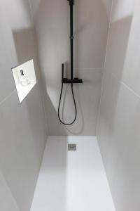 a shower in a white room with a sign on the wall at Coco: hypercentre-2chambres-parking-zen... in Saint-Étienne