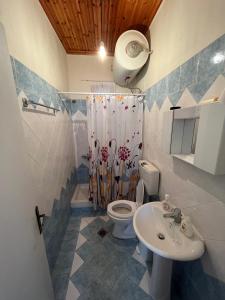 a bathroom with a toilet and a sink at Panorama House in Pramanta