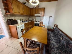 a kitchen with a wooden table and a refrigerator at Panorama House in Pramanta