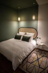 - une chambre avec un grand lit blanc et 2 oreillers dans l'établissement Coco: hypercentre-2chambres-parking-zen..., à Saint-Étienne