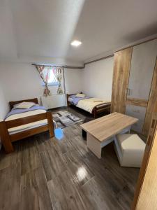 Cette chambre comprend 2 lits et une table. dans l'établissement Apartmani Albatros, à Perušić
