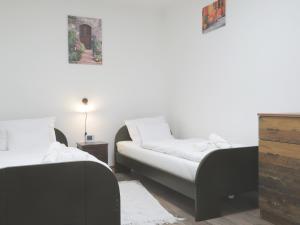 een slaapkamer met 2 bedden en een dressoir bij Hegyköz Vendégház 