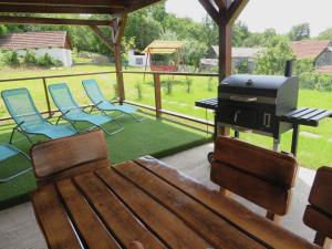 a patio with chairs and a grill and a table at Hegyköz Vendégház in Pusztafalu