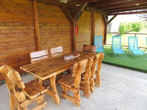 a wooden table and chairs in a cabin at Hegyköz Vendégház in Pusztafalu