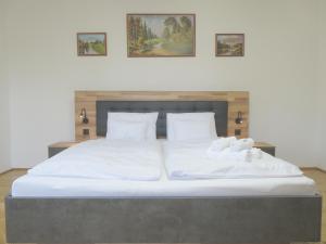 a large bed with two white towels on it at Hegyköz Vendégház in Pusztafalu +18 photos