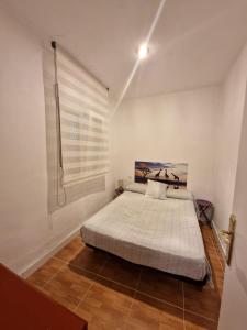 a bedroom with a bed in a room with a window at La casa de Emma in Piles