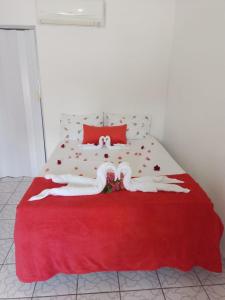 - une chambre avec un lit et une couverture rouge dans l'établissement Pousada encontro das flores, à Gravatá