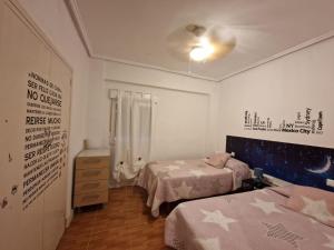 a small bedroom with two beds and a dresser at La casa de Emma in Piles