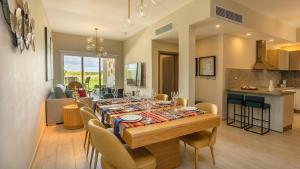 a dining room table with chairs and a kitchen at Luxury Pool & Golf View Aptin in Hard Rock Golf PC in Punta Cana