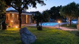 une maison en pierre avec une piscine la nuit dans l'établissement Villa De La Seliga, à Sant Antonio Di Gallura