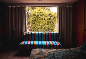 a room with a chair in front of a window at Suites Cuija Coyoacan in Mexico City
