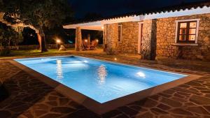 - une piscine en face d'une maison la nuit dans l'établissement Villa De La Seliga, à Sant Antonio Di Gallura