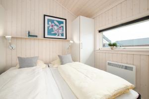 Duas camas num pequeno quarto com uma janela em Resort 2 Ferienhaus Typ D 35 em Grossenbrode