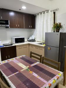 eine Küche mit einem Tisch und einem Kühlschrank in der Unterkunft Alitheia Condo @ Pine Suites Tagaytay in Tagaytay
