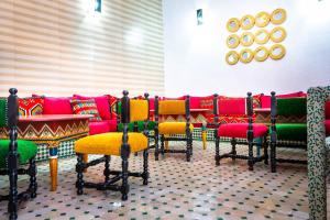 a row of chairs with red and green seats at Riad La Croix Berbere in Marrakesh