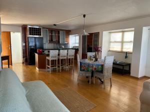 una cucina e un soggiorno con tavolo e sedie di Beach Vibes Clifton! a Città del Capo