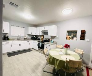 a kitchen with a table and a kitchen with white cabinets at 2Bed/1Bath Fully Upgraded Suite in Glendale