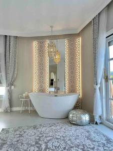 uma casa de banho com uma banheira grande e um espelho. em Mil y un momentos mágicos: Villa con encanto árabe em Marbella