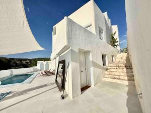 uma casa branca com escadas e uma piscina em Mil y un momentos mágicos: Villa con encanto árabe em Marbella
