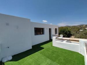 Casa blanca con césped verde en el balcón en Mil y un momentos mágicos: Villa con encanto árabe en Marbella