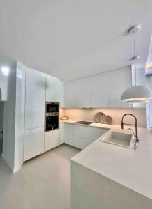 uma cozinha com armários brancos e um forno com placa de fogão em Mil y un momentos mágicos: Villa con encanto árabe em Marbella