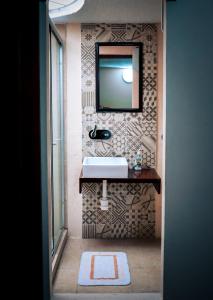 baño con lavabo y espejo en la pared en Suites Cuija Coyoacan, en Ciudad de México