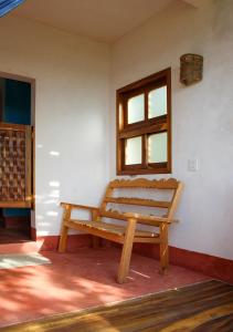 een houten bank in een kamer met een raam bij Posada La Sabila in Mazunte