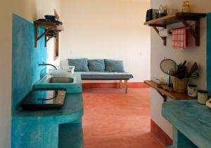 a bathroom with a blue sink and a couch at Posada La Sabila in Mazunte