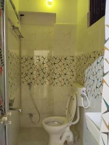 a small bathroom with a toilet and a shower at Shubham guest house in Muzaffarpur